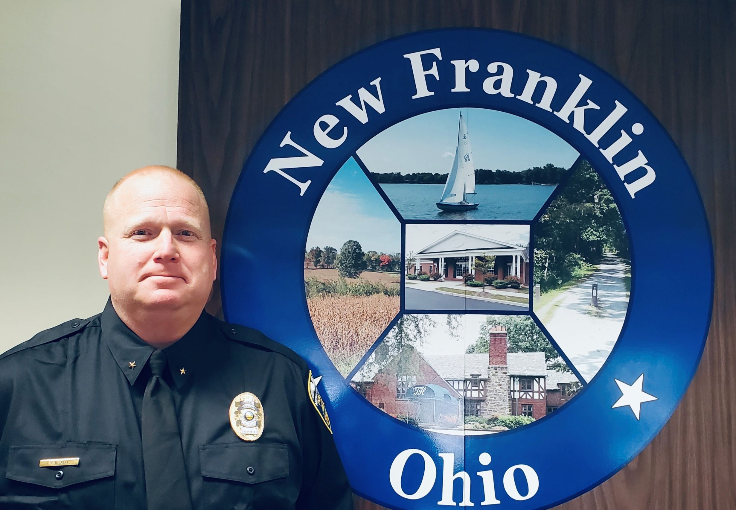 Chief Bickett in front of New Franklin city seal